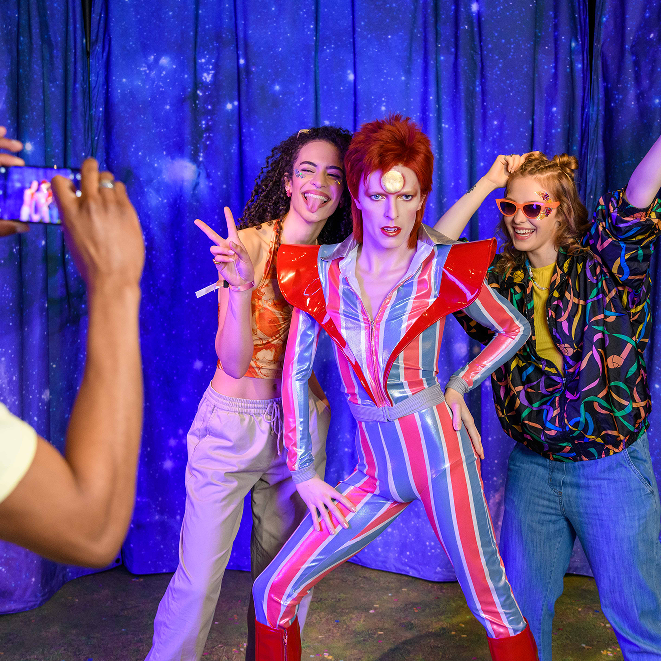 Guests Pose For A Picture With David Bowie Figure At Madame Tussauds London